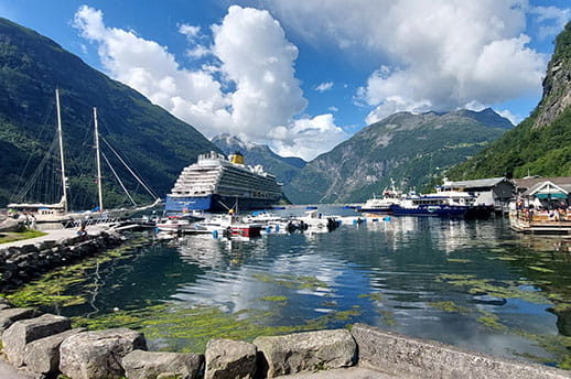 Spirit of Discovery docked in Geiranger, Norway, with a view of the mountains